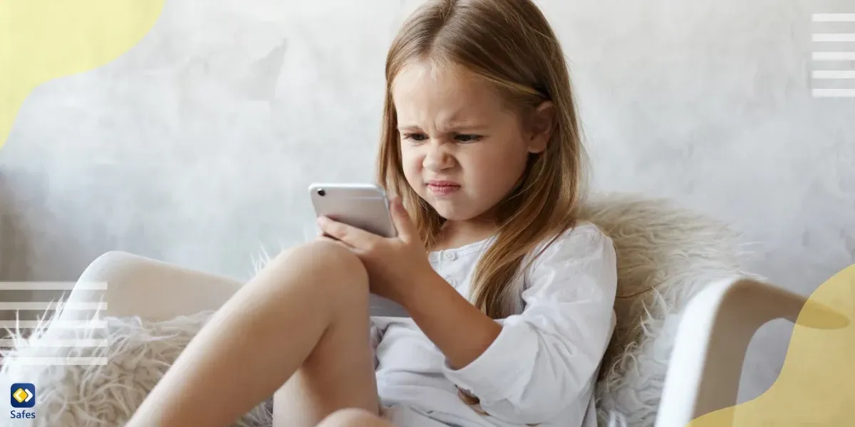 Annoyed little girl looking at phone