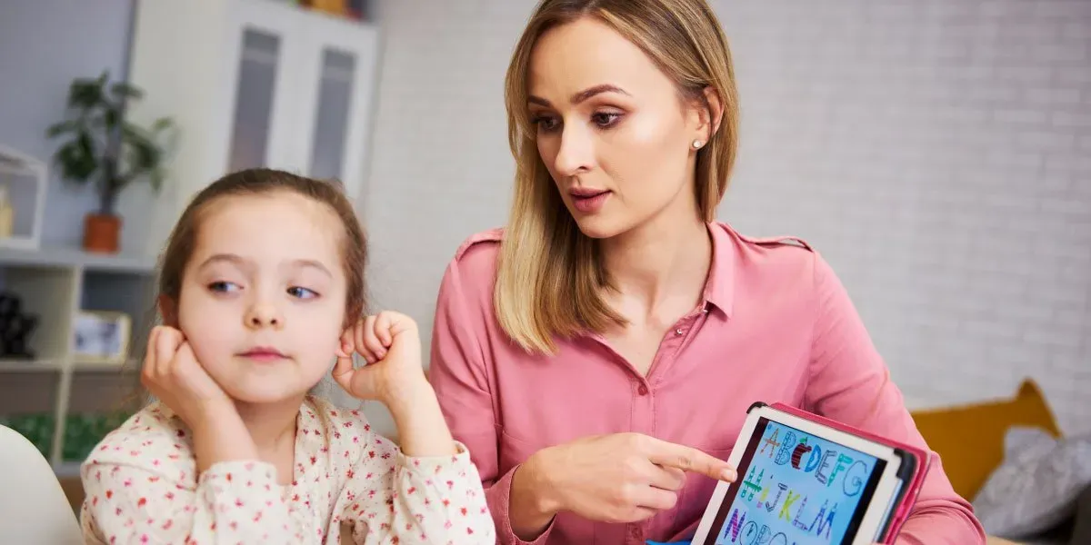 Bored girl and her mother studying with laptop at home