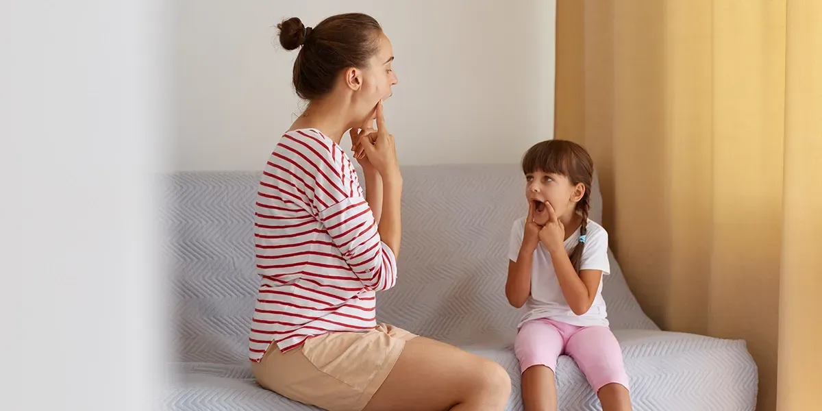 Parent and child sitting on couch making a face