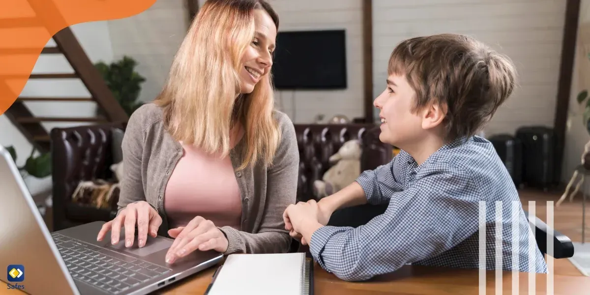 Mother and son smiling and talking over a laptop