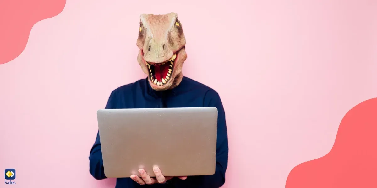 Man with a dinosaur mask using a laptop