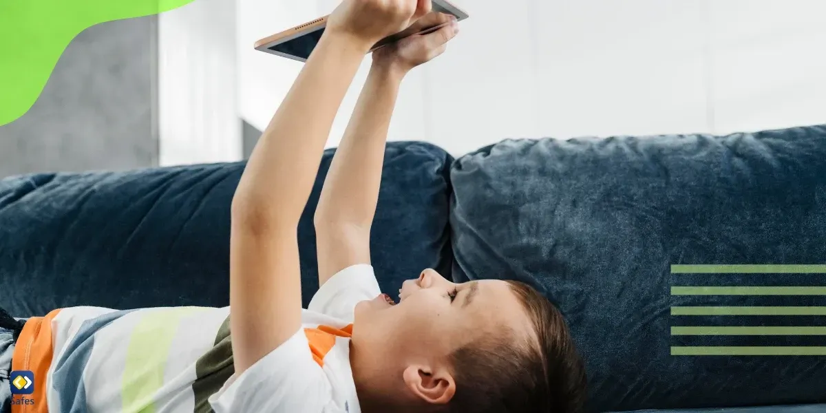 Child laying on couch using tablet